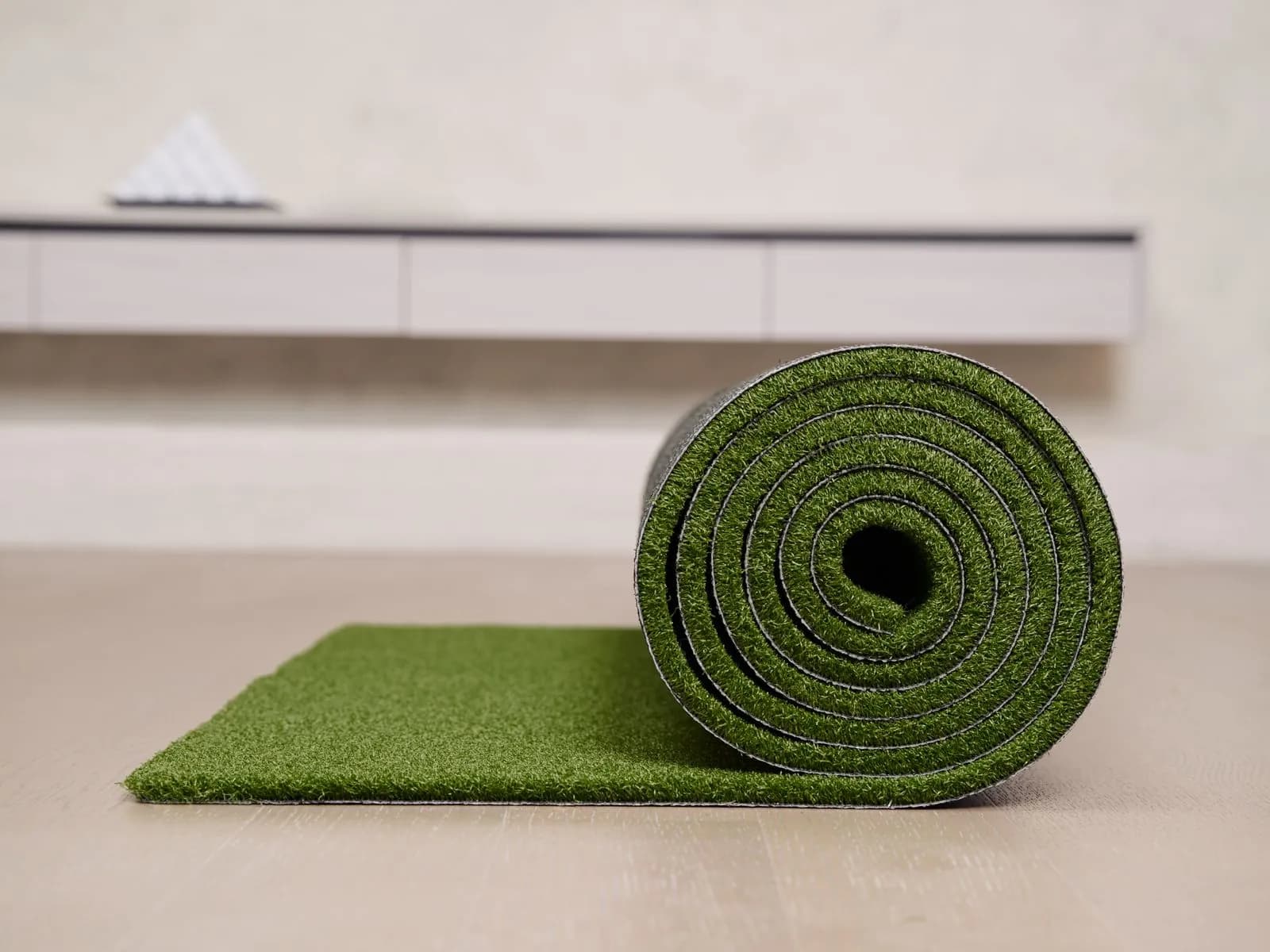 Roll of artificial grass turf being unrolled during installation in a UAE garden