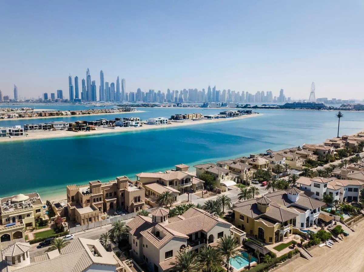 Aerial view of Palm Jumeirah frond villas and their gardens along the Dubai shoreline