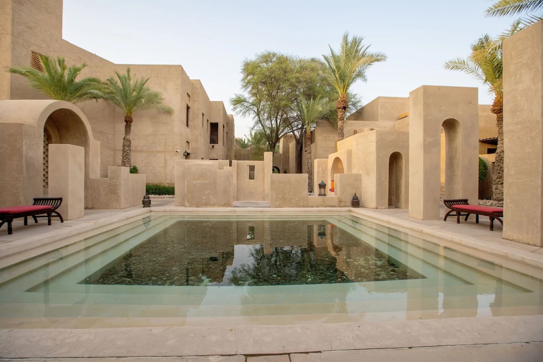 Traditional Arabic courtyard garden in Ajman with a central reflecting pool, sandstone paving and citrus planting by Absher Landscaping