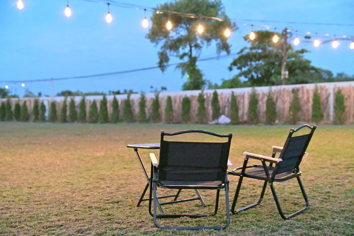 Festoon string lights over a family garden at evening in Sharjah