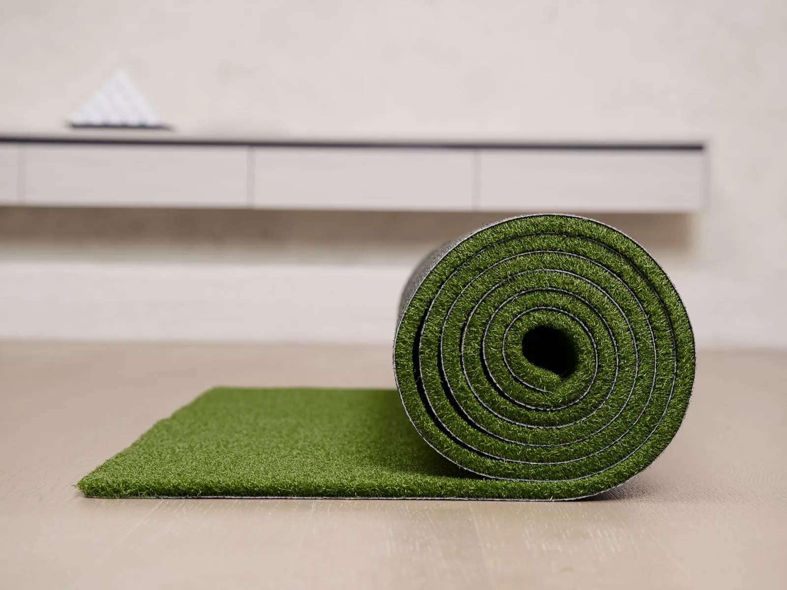 Roll of artificial grass turf being unrolled during installation in a UAE garden