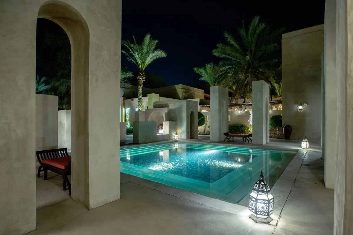 Arabic courtyard garden lit at night with brass lanterns and warm LED lighting at an Ajman villa