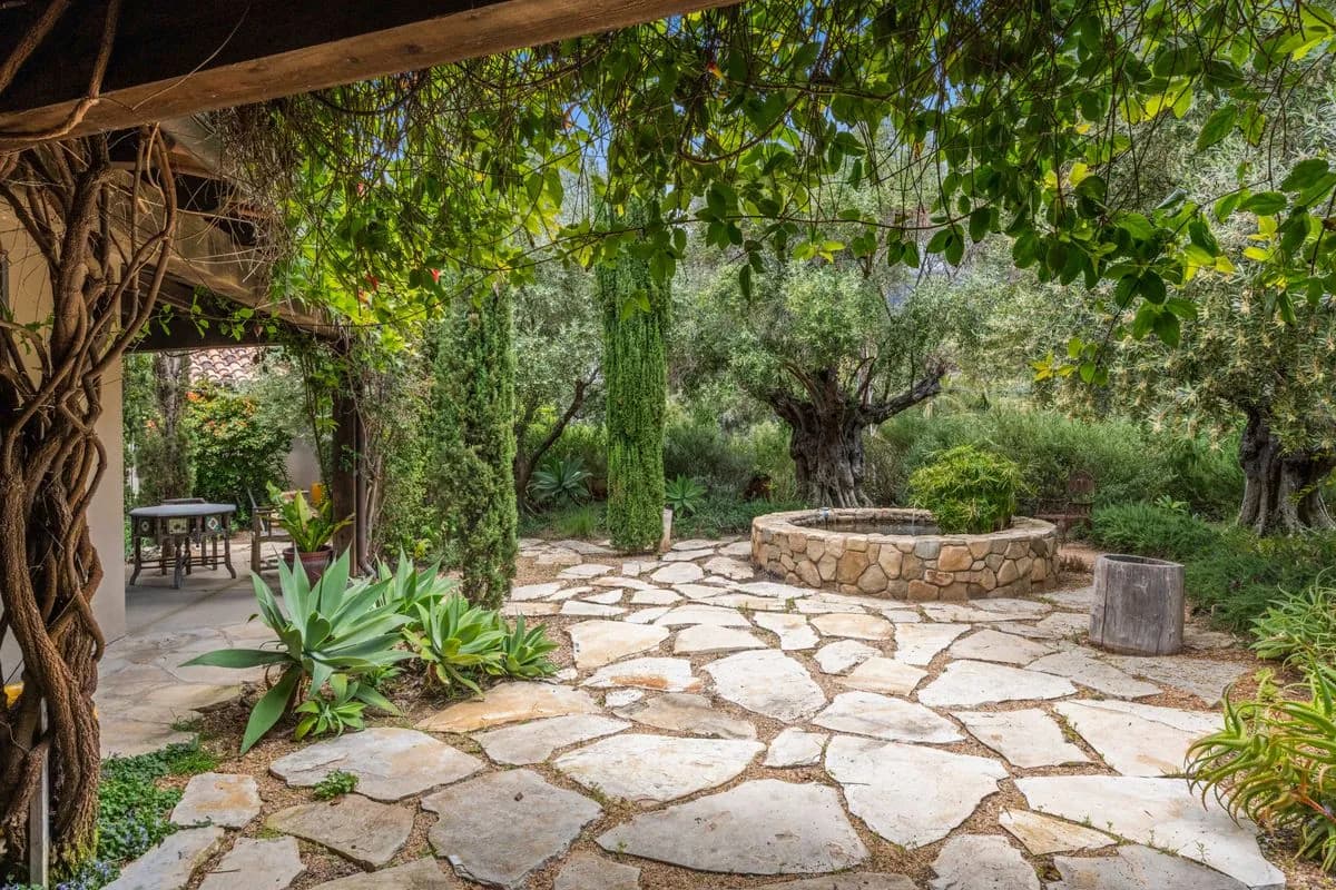 Honed sandstone courtyard with a carved stone reflecting pool at an Ajman villa